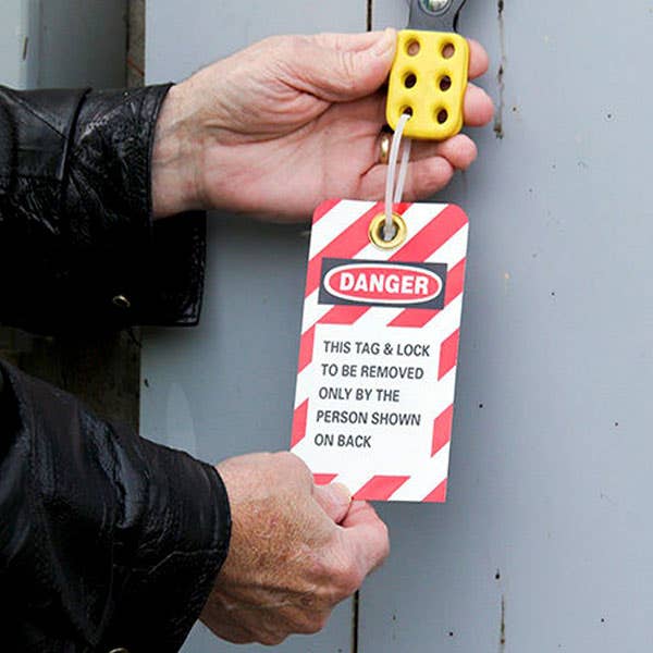 Image of hands holding a lockout/tagout tag