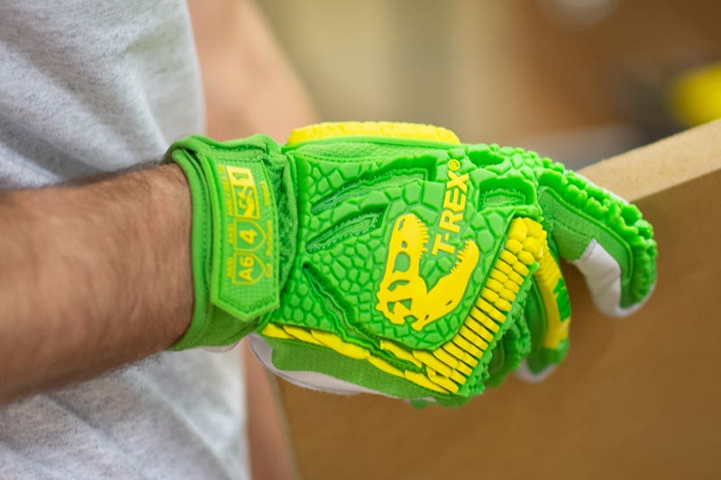 Magid T-Rex impact gloves holding a metal piece